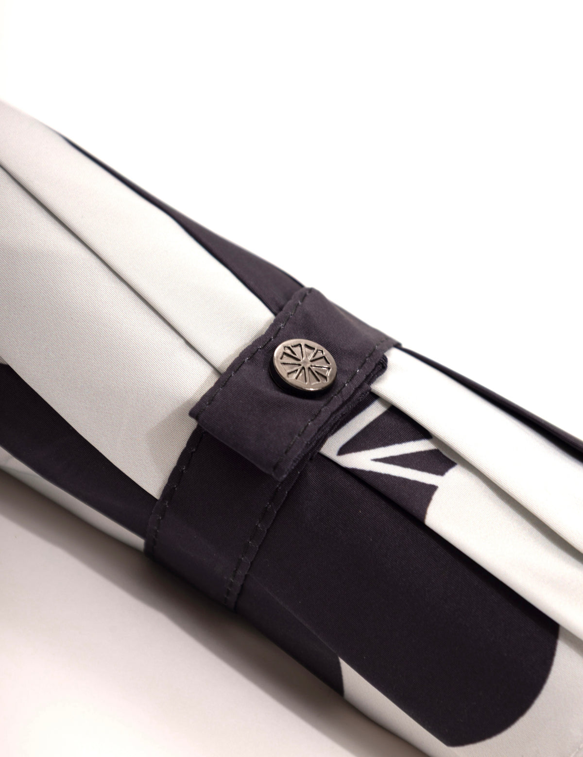 Detail des Verschlussbands eines Sapor Essential Taschenschirms mit Black-Drop-Motiv