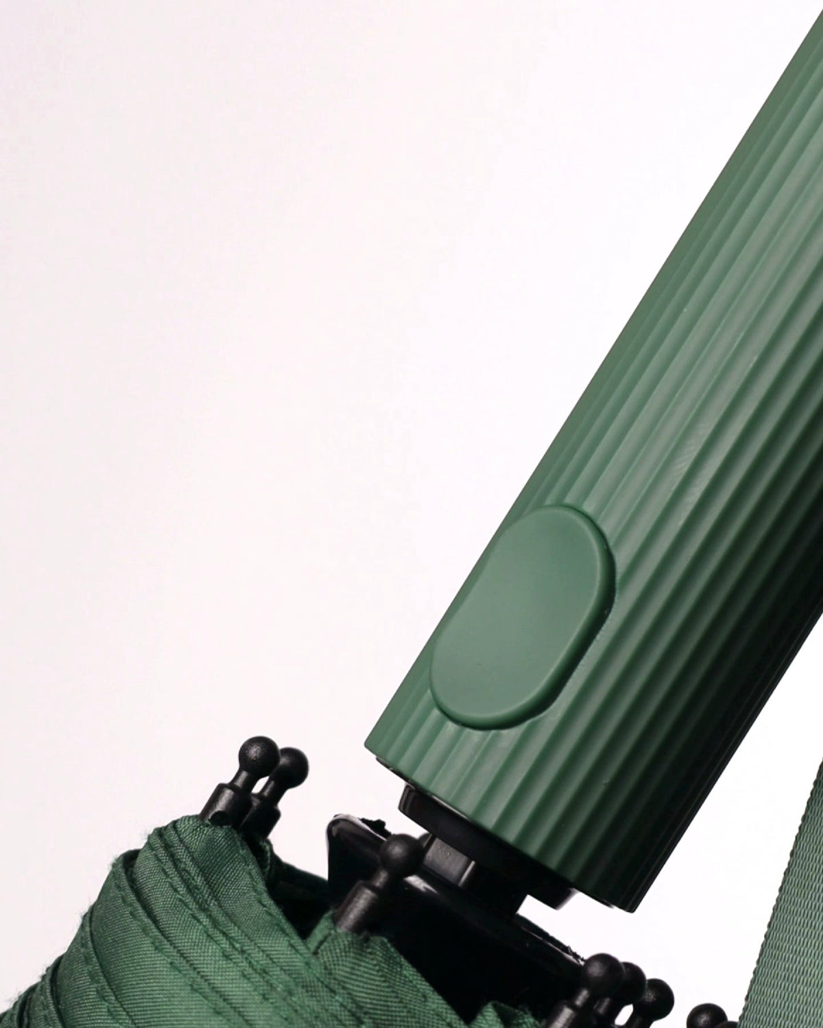 Automatikknopf am geriffelten Griff eines grünen Sapor Taschenschirms