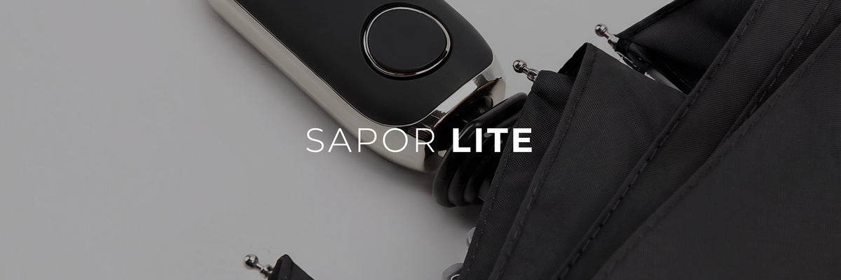 Nahaufnahme des schwarzen Sapor Lite Taschenschirms mit Logo-Schriftzug