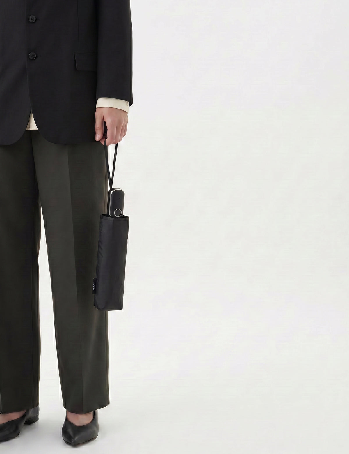 Person mit geschlossenem schwarzem Sapor Lite Taschenschirm